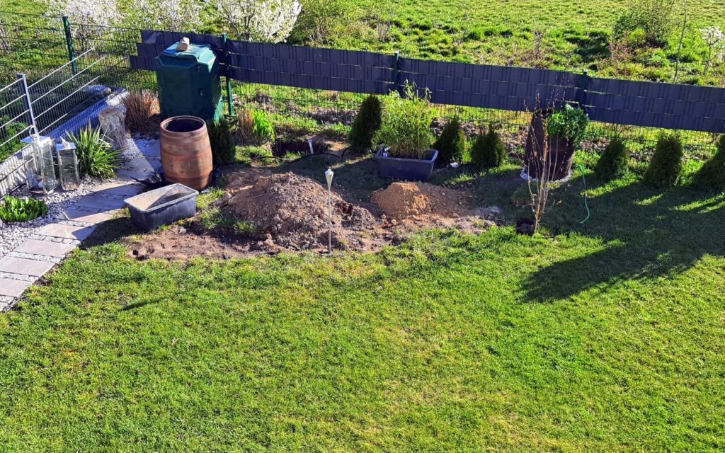 neuer Gartenbereich mit Pflanzfass, Bäumchen und Kompost